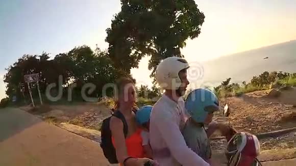 快乐的一家人在热带骑摩托车阳光明媚的一天泰国范甘视频的预览图
