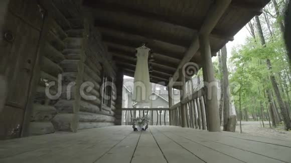 白色婚纱挂在木屋上视频的预览图