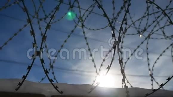 监狱里的铁丝网阳光照耀着蓝天的背景视频的预览图