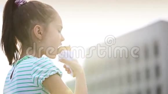 漂亮的小女孩在街上吃冰淇淋视频的预览图