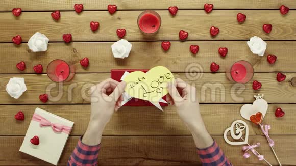 男人把情人节的心放在礼品盒上俯视视频的预览图