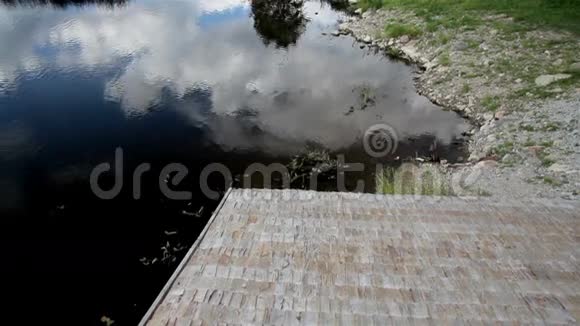 小木屋和木瓦屋顶附近池塘的宁静景色视频的预览图