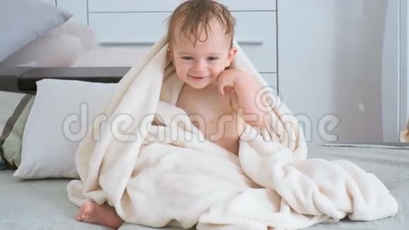 可爱的小男孩被毯子覆盖在床上爬行视频的预览图