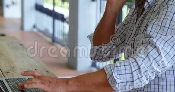 使用4k笔记本电脑时老人在用手机说话视频的预览图