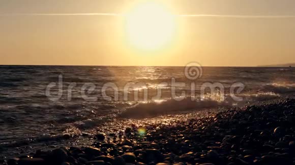 日落时海边的巨浪橙色太阳背景下美丽的慢动作视频视频的预览图
