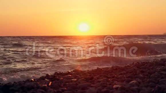 日落时海边的巨浪橙色太阳背景下美丽的慢动作视频视频的预览图