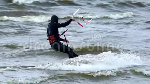 下情中年男子从事风筝活动他在湖面的波浪上美丽地骑着风筝强风视频的预览图