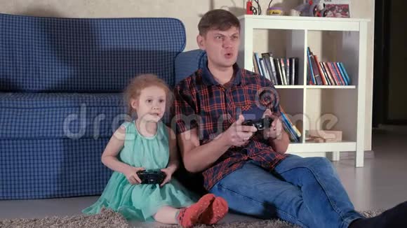夫妻和女儿在客厅里玩电子游戏视频的预览图