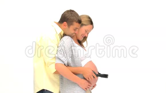 男人把耳机戴在怀孕妻子的肚子上视频的预览图