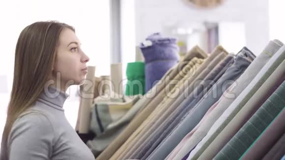 年轻漂亮的女人在纺织店挑选布料视频的预览图