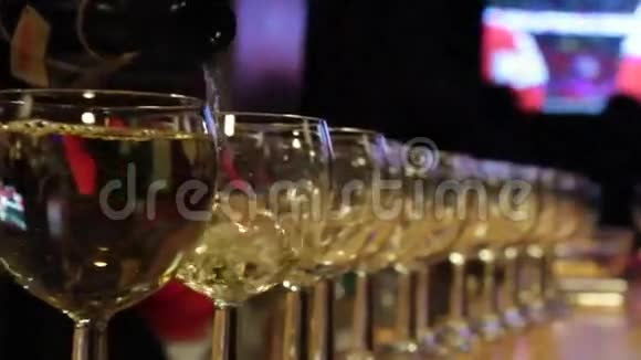 白葡萄酒倒在许多玻璃杯里视频的预览图
