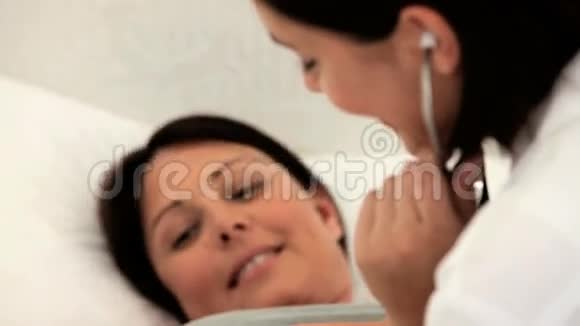 护士倾听她怀孕病人的腹部视频的预览图