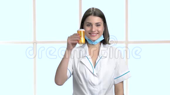 微笑的女医生拿着瓶子和药丸视频的预览图