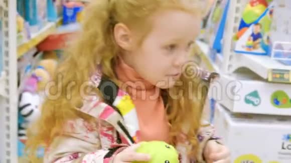 一个漂亮的女孩走在超市边挑选玩具视频的预览图