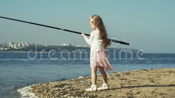 可爱的小女孩正在河边的渔船上玩鱼竿视频的预览图