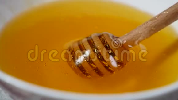 在盛满蜂蜜的碗里用蜂蜜蘸汁把蜂蜜滴上视频的预览图