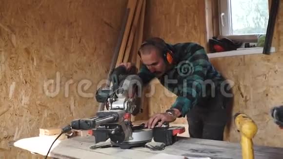 有胡子的大胆木匠在他的车间里用圆锯做木头视频的预览图