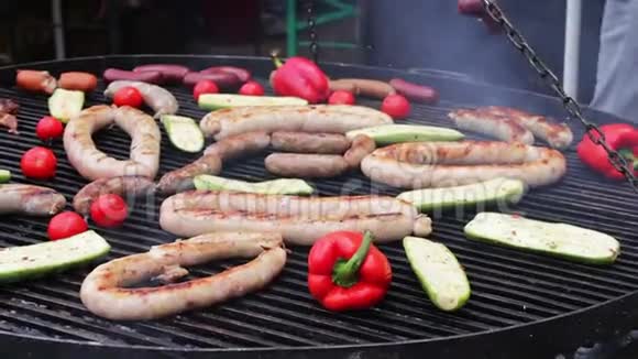 一个巨大的烤架美观地放置烤香肠甜椒蔬菜鸡肉街头美食快视频的预览图