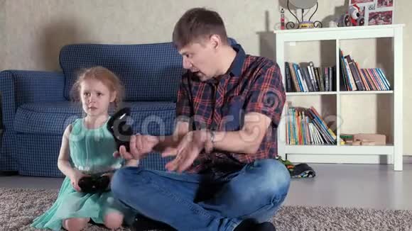 夫妻和女儿在客厅里玩电子游戏视频的预览图