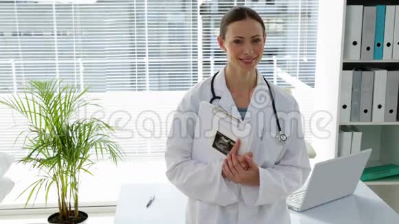 医生靠在桌子上对着摄像机微笑视频的预览图