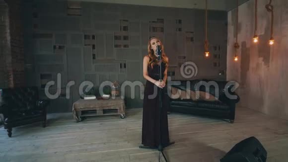 有魅力的爵士歌手穿着黑色礼服在音乐会话筒前表演视频的预览图
