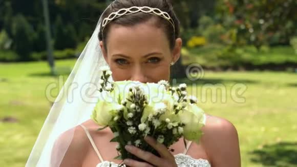 新娘在公园里闻着她的花束视频的预览图