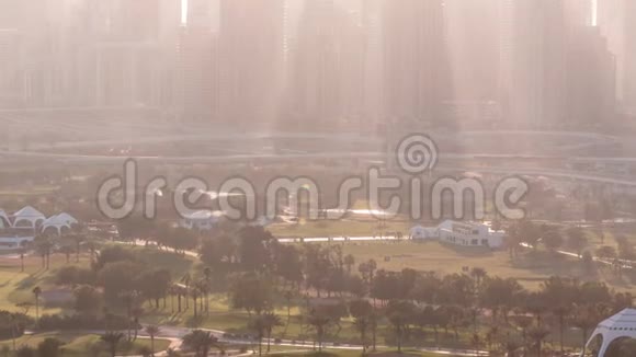 阿拉伯联合酋长国迪拜日落时分的高尔夫球场和迪拜码头摩天大楼视频的预览图