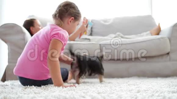 小女孩在沙发上和妈妈一起玩小狗和骨头视频的预览图