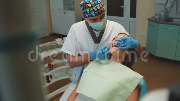 年轻漂亮的女孩在牙科室接受治疗和咨询视频的预览图