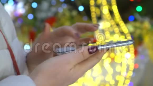 特写镜头女性手拿智能手机彩色背景视频的预览图