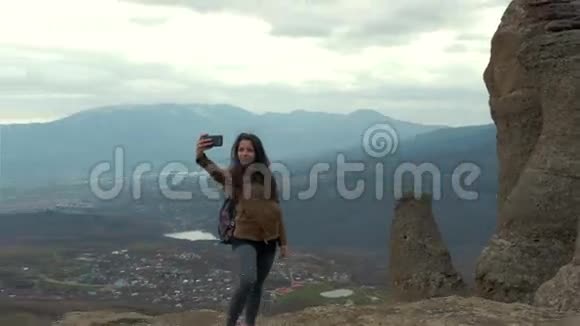 年轻女子徒步旅行者用智能手机拍照视频的预览图