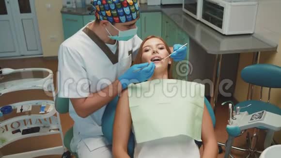 年轻漂亮的女孩在牙科室接受治疗和咨询视频的预览图
