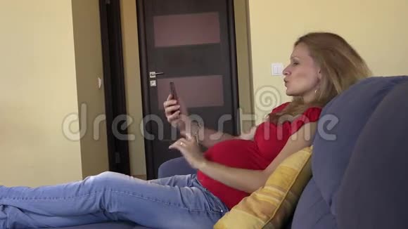 孕妇用智能手机浏览照片和上网视频的预览图