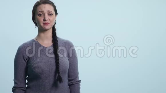 年轻悲伤的女人在白色背景下哭泣视频的预览图