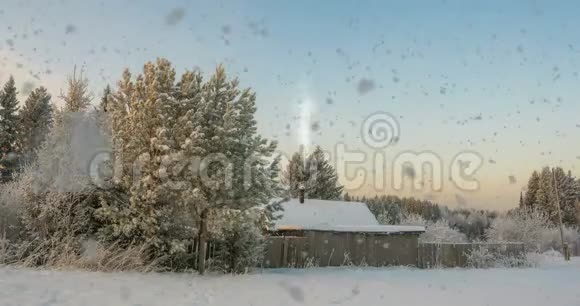 森林附近的一个小木屋夕阳下一场美丽的降雪一道美丽的冬季景观视频循环视频的预览图