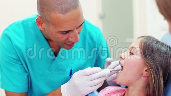 关闭牙科助理检查小女孩的牙齿视频的预览图