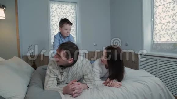 幸福的家庭在现代室内的床上视频的预览图