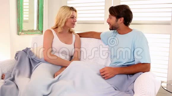 深情的一对夫妇坐在沙发上铺着毯子视频的预览图