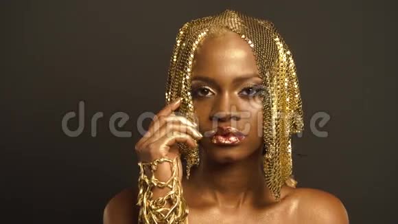 美国黑人妇女的超现实肖像有光泽的金色化妆和头饰青铜体彩视频的预览图