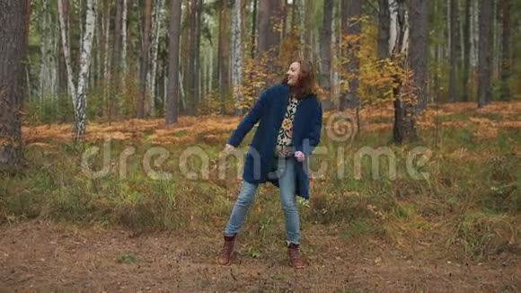快乐的女孩跳舞在秋天的森林里玩得开心视频的预览图