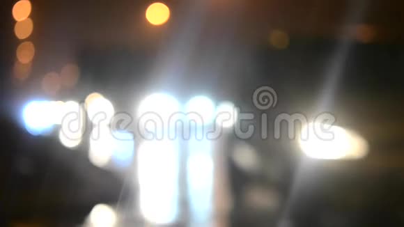 模糊的背景汽车在城市的一条潮湿的道路上行驶晚上视频的预览图