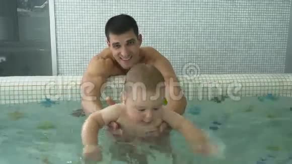 在儿童泳池里给他的孩子洗澡视频的预览图