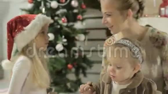 一家人坐在装饰好的圣诞树旁视频的预览图
