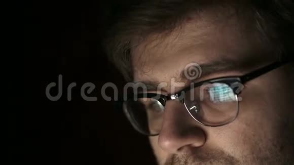 一个戴眼镜的年轻人晚上工作的肖像关门视频的预览图