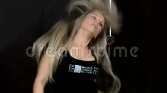 金发女人长发舞走特写独立动作慢动作黑色背景视频的预览图