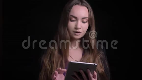 年轻迷人的白种人女性的特写镜头使用的平板电脑背景隔离在黑色视频的预览图