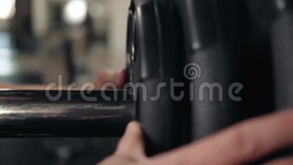 在健身房里用杠铃做运动把杠铃牌放在手里宏观调控视频的预览图