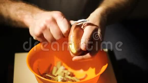 为准备食物而在厨房剥土豆皮的男人视频的预览图