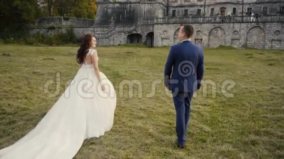 新婚夫妇在城堡前散步视频的预览图