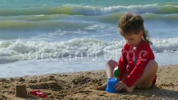 在海边沙滩上玩沙子的男孩视频的预览图